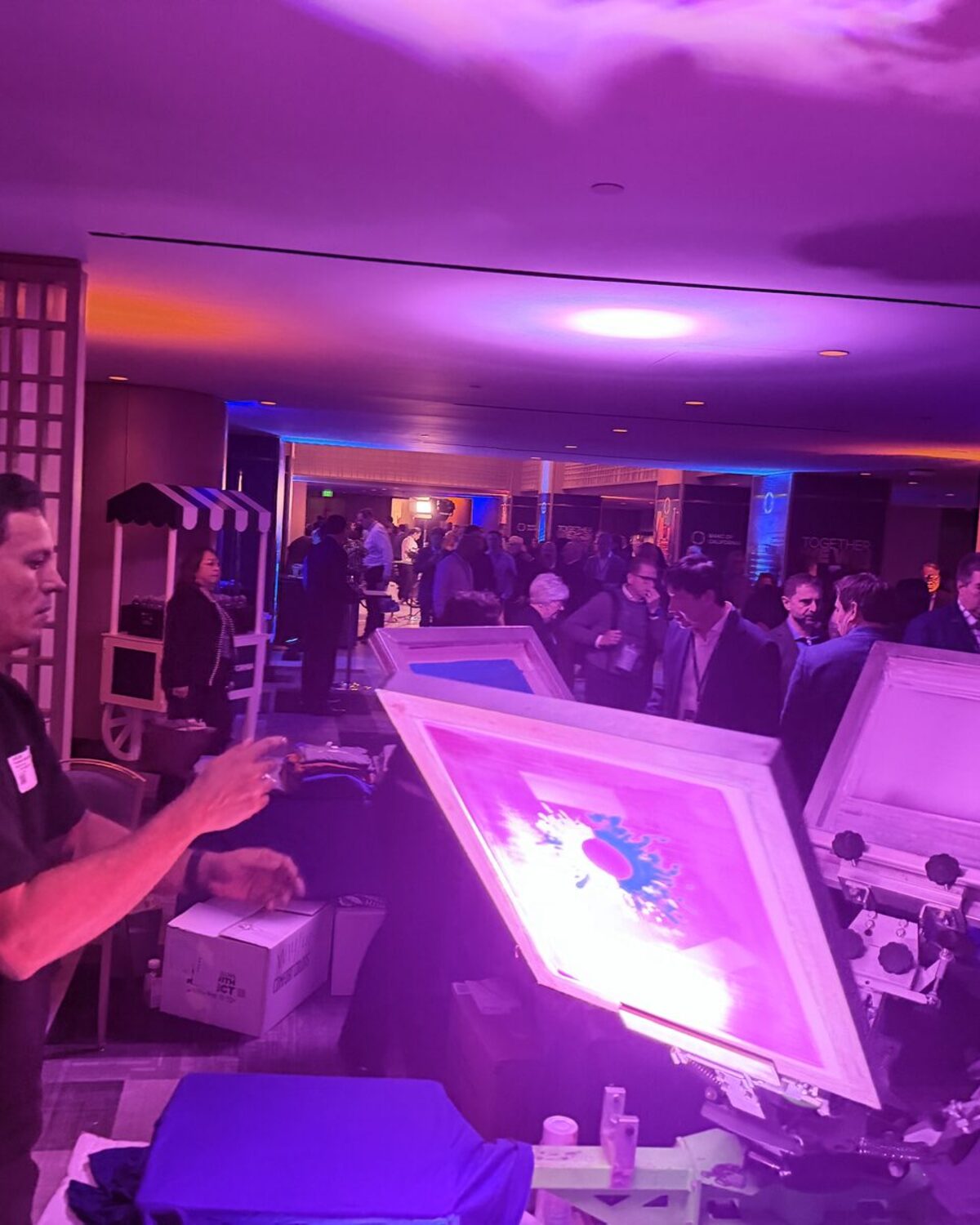 Operator running a live customization station in a hotel ballroom during a corporate evening event